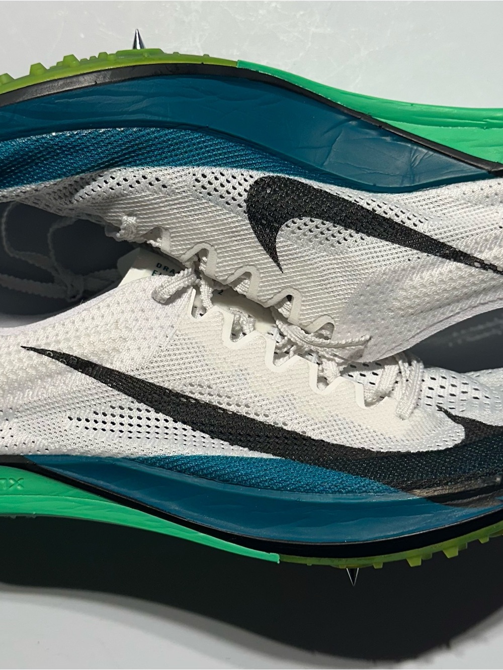 Nike Men’s White Athletic Spike Shoes with Black Swoosh and Green Accents